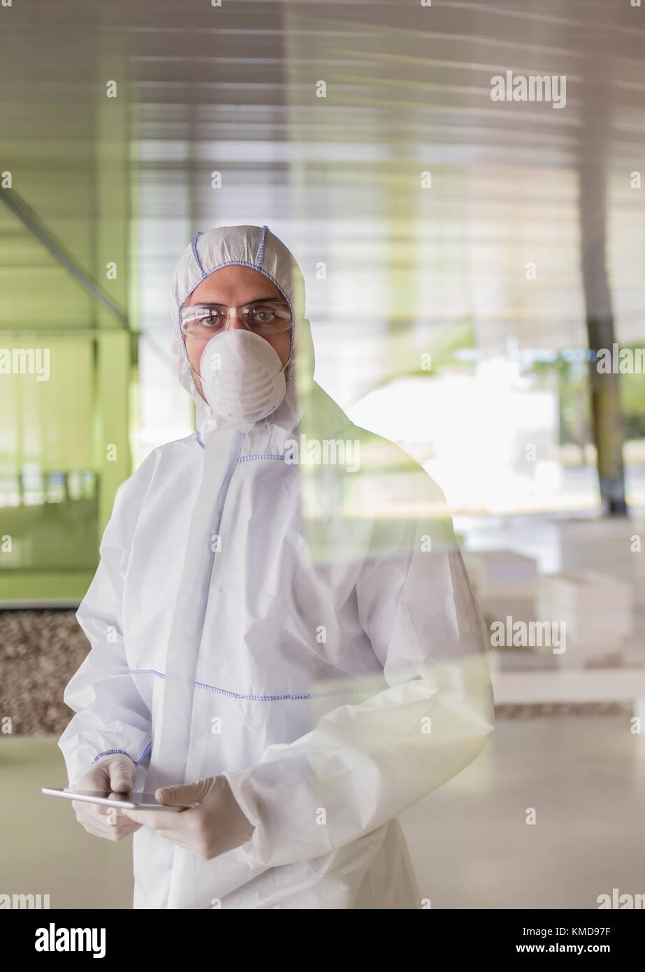 Ritratto uno scienziato serio in tuta pulita utilizzando un tablet digitale Foto Stock