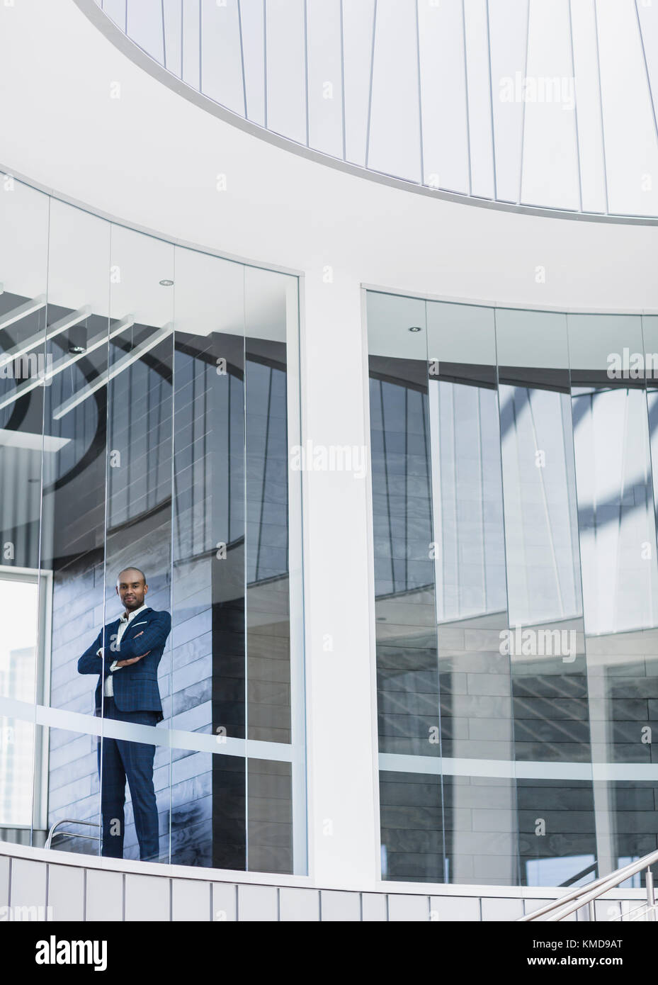 Ritratto sicuro, serio uomo d'affari CEO in piedi alla moderna finestra dell'ufficio Foto Stock