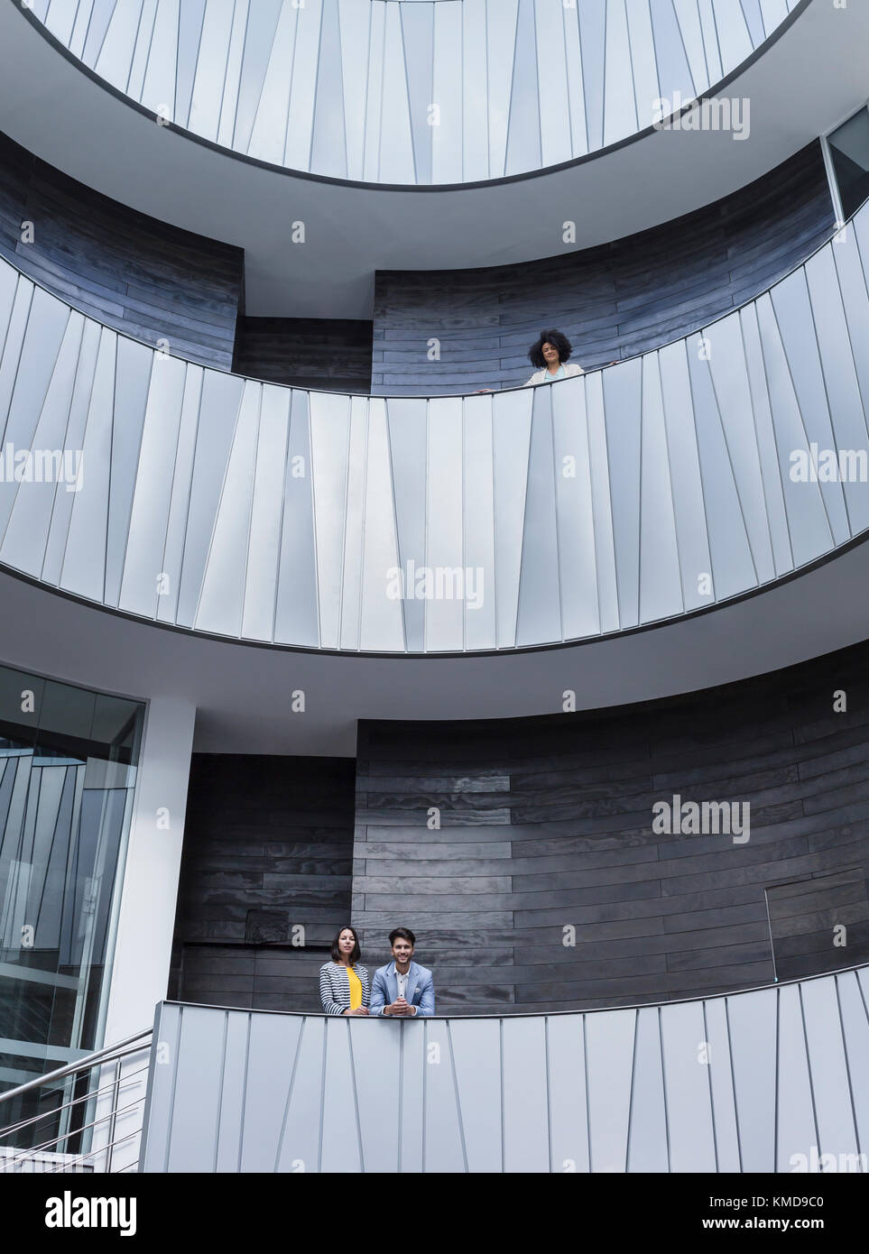 Ritratto di uomini d'affari che si erige su edifici architettonici, moderni balconi dell'atrio dell'ufficio Foto Stock