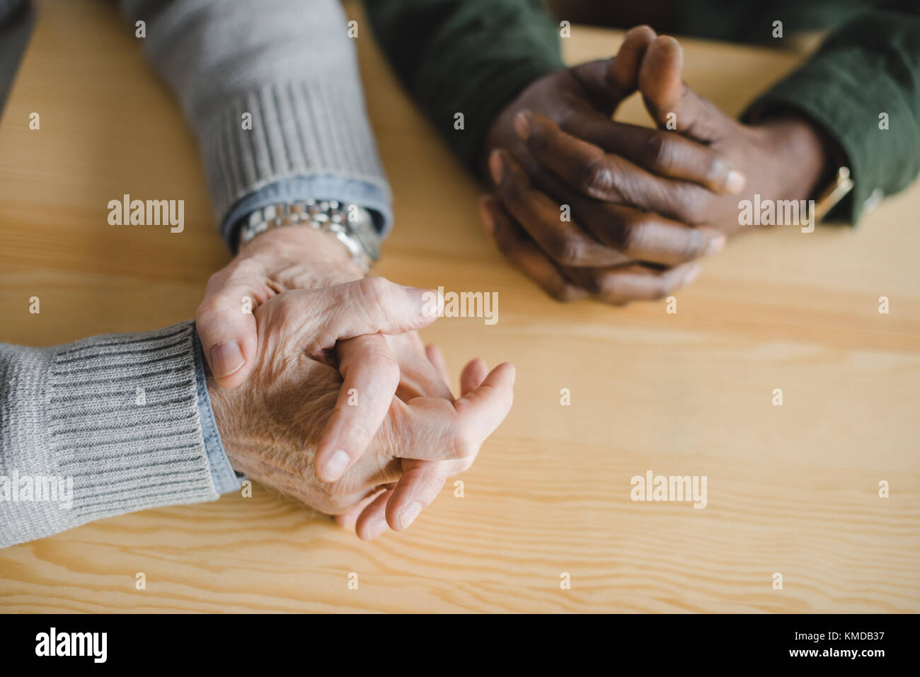 Multietnica gli uomini con le mani sul tavolo Foto Stock Multietnica gli uomini con le mani sul tavolo Foto Stock