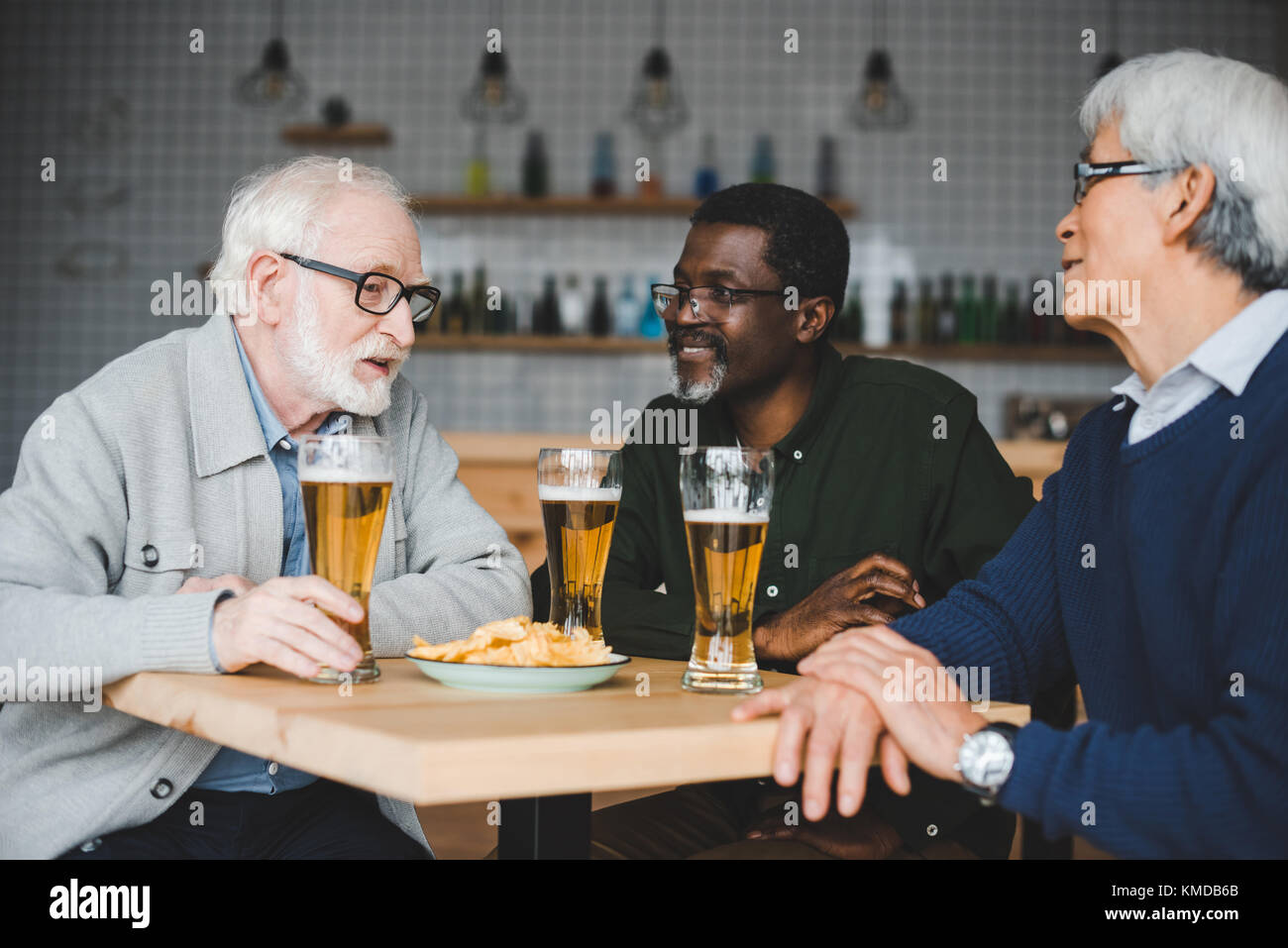 Senior gli amici a bere la birra nel bar Foto Stock