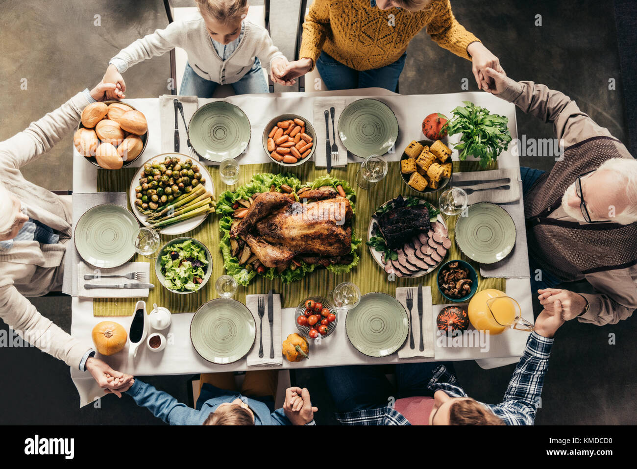 Famiglia pregare prima di cena per le vacanze Foto Stock
