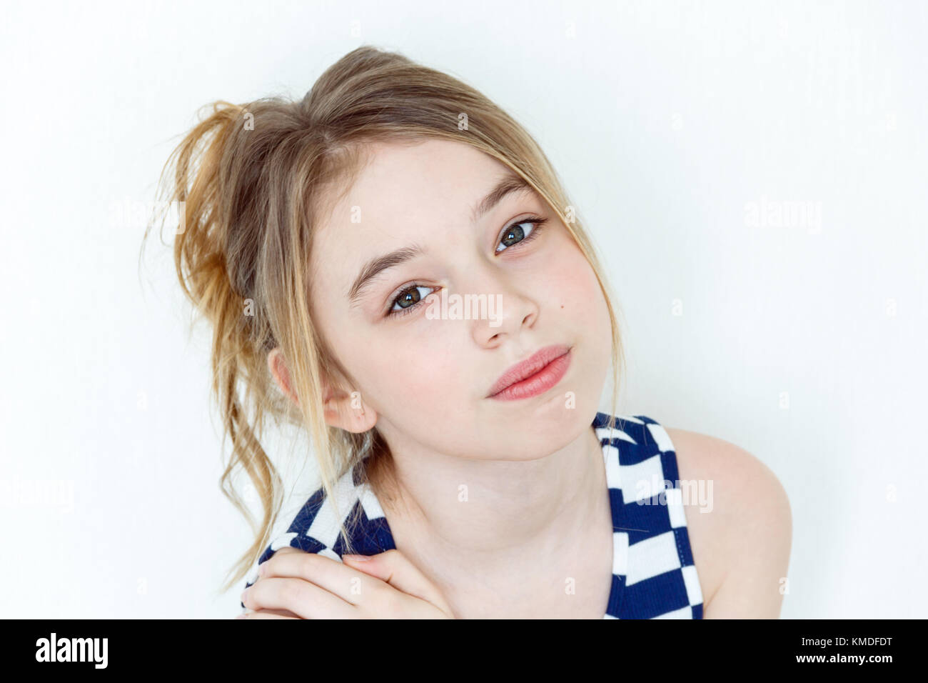 Ragazza carina undici anni bionda con i capelli lunghi e grandi occhi su bianco Foto Stock