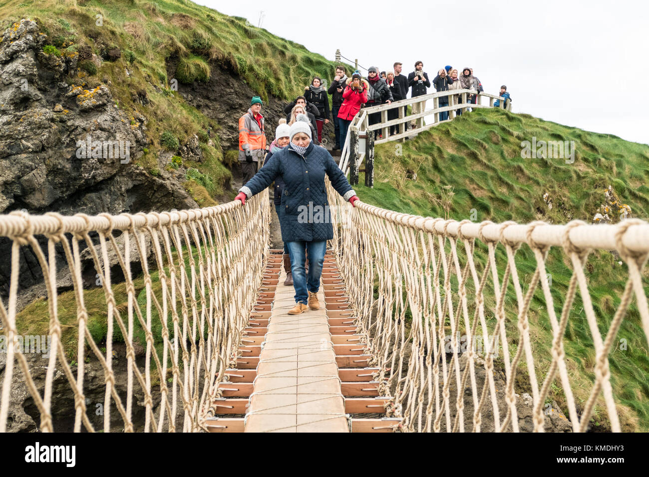 Visitatori attraversando il famoso 'Carrick-a-Rede' ponte sulla costa di Causeway, Isola Settentrionale Foto Stock