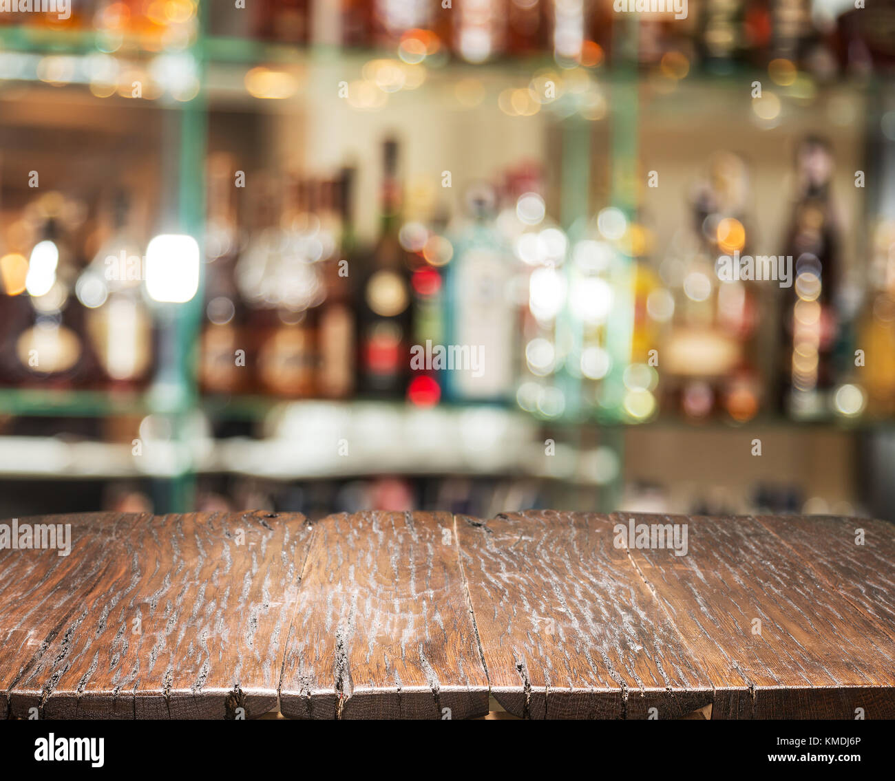 Il ripiano del bancone in legno e sfocata bar ripiani in background. Foto Stock