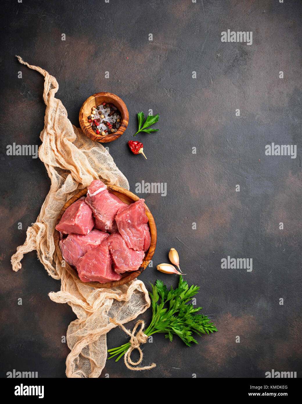 Materie carne tritata con spezie su sfondo arrugginito Foto Stock