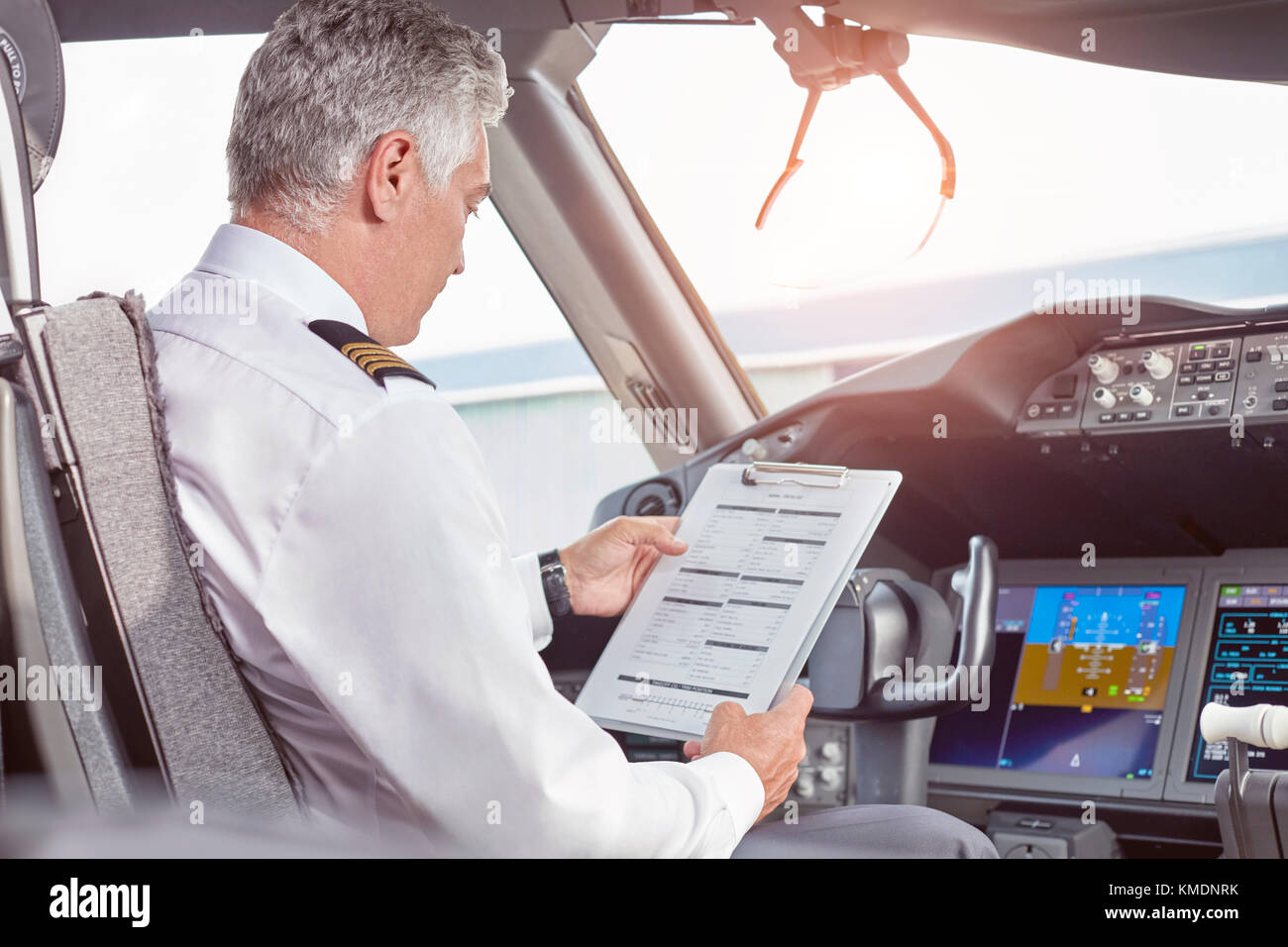 Pilota maschio con la preparazione degli appunti in aereo cockpit Foto Stock