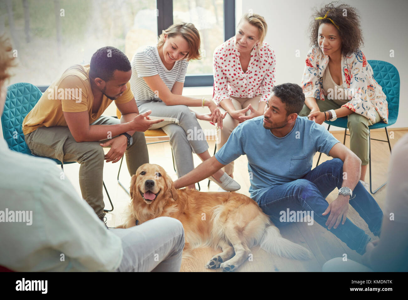 Persone che accarezzano il cane nella sessione di terapia di gruppo Foto Stock