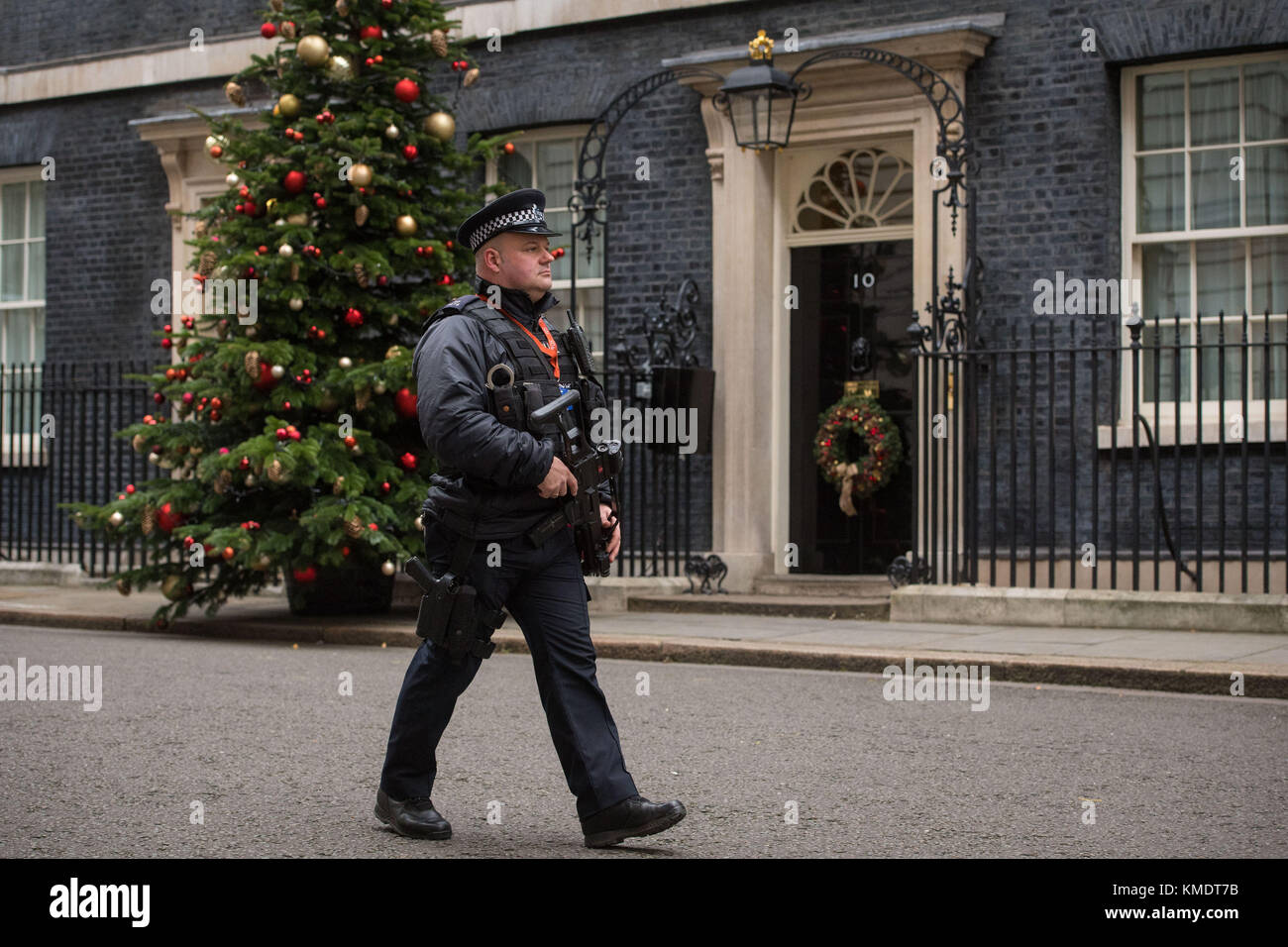 Un poliziotti armati passeggiate oltre la porta di 10 Downing Street a Londra. Naa'imur Zakariyah Rahman è apparso a Westminster Magistrates Court accusato di cospirazione per assassinare il PM in una bomba a orologeria e attacco di coltello a Downing Street. Foto Stock
