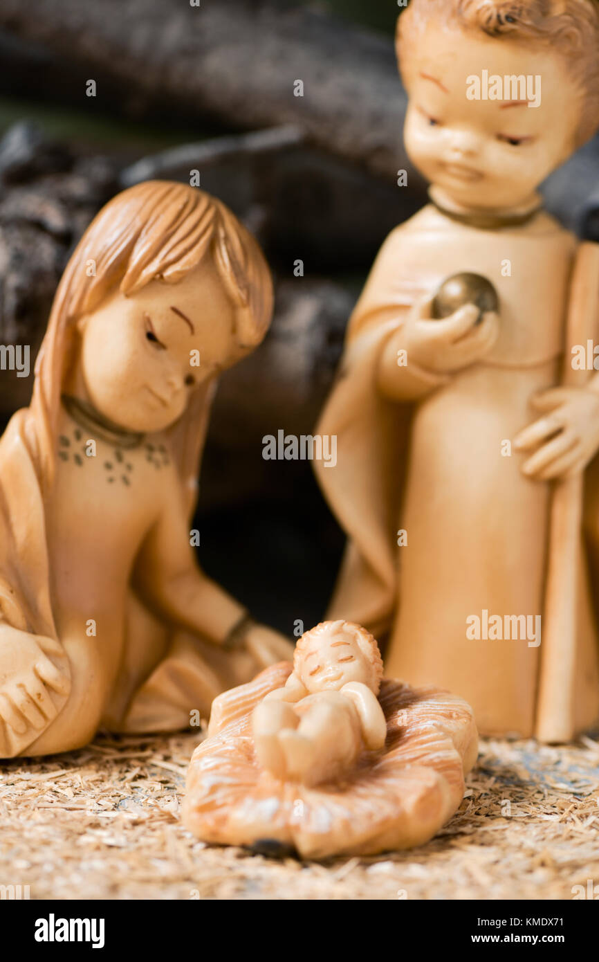 La Santa Famiglia, il Bambino Gesù, la Vergine Maria e San Giuseppe in un rustico presepe con il focus sul Bambino Gesù Foto Stock