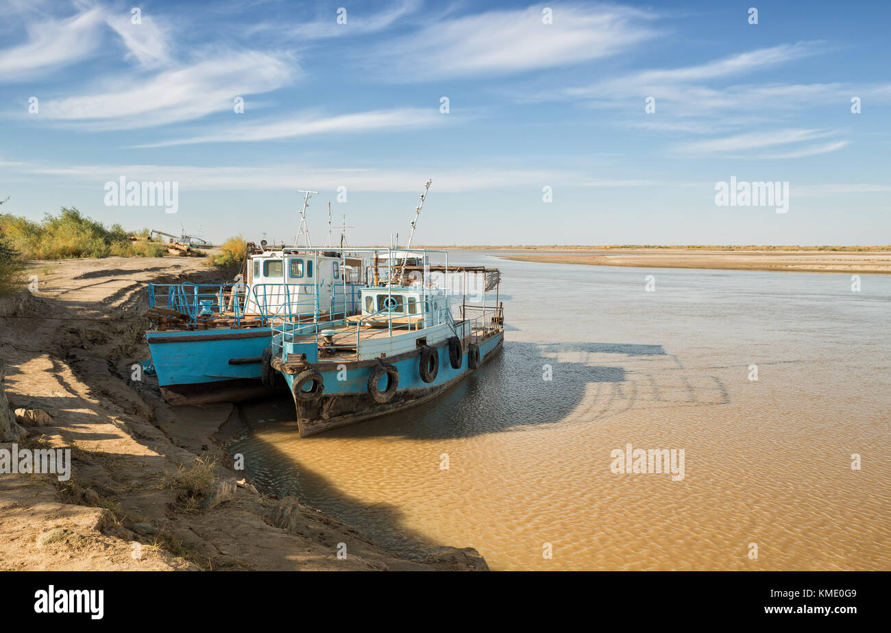 Amudarja nella parte inferiore del fiume. due vecchie barche sono ormeggiate a riva. Foto Stock