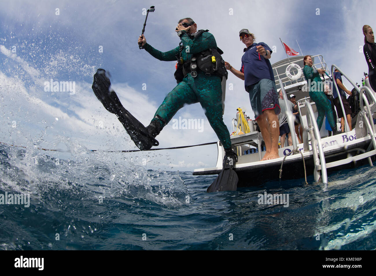 Scuba Diver entra in acqua facendo stride gigante. Foto Stock