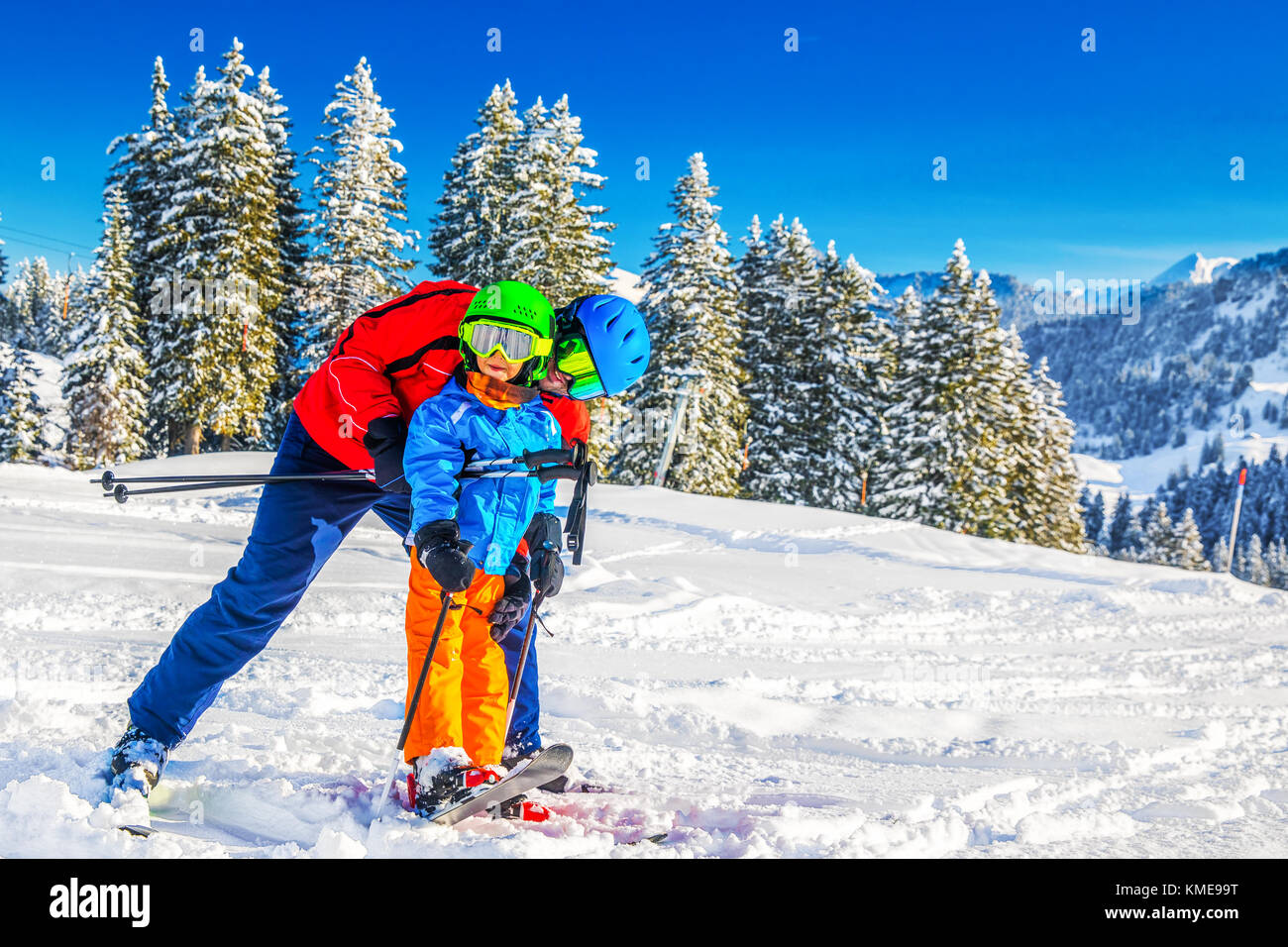 Happy little boy divertendosi con suo padre sulla vacanza sciistica nelle Alpi. Foto Stock