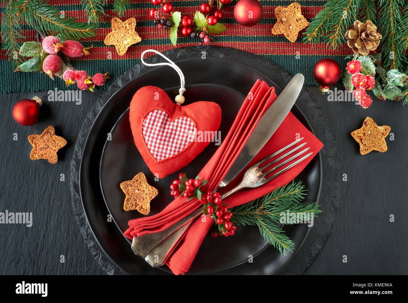 Menu di natale concetto su pietra scura sullo sfondo di ardesia nera piatti  e posate vintage con decorazioni di Natale in verde, rosso e arancione Foto  stock - Alamy