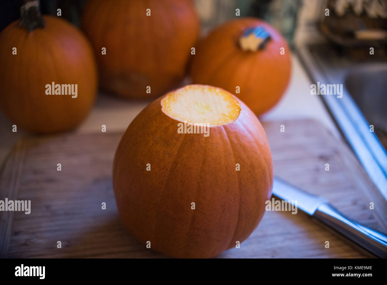 Piccola zucca di zucchero con il top cut off posa su un tagliere Foto Stock