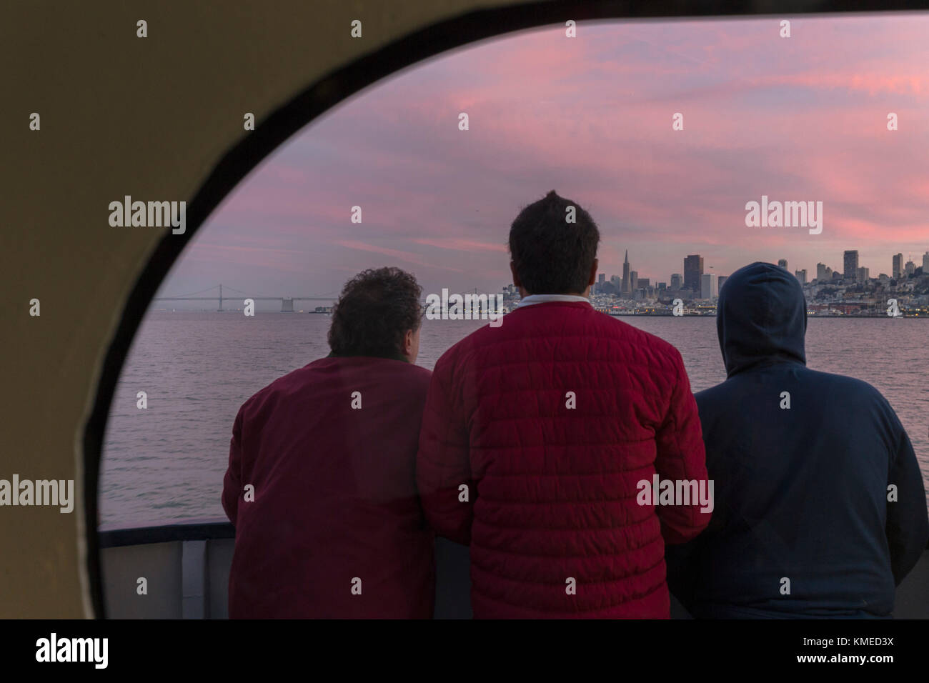 Vista posteriore di tre passeggeri in traghetto da Sausalito a. San Francisco guardando la vista della città, California, Stati Uniti Foto Stock