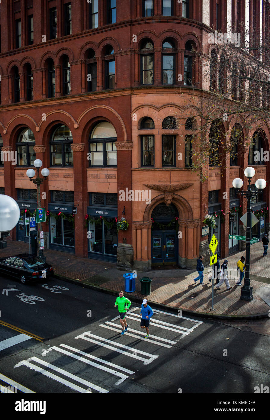 Due guide maschio attraversate la strada a Seattle il Pioneer Square durante un pomeriggio eseguite. Foto Stock