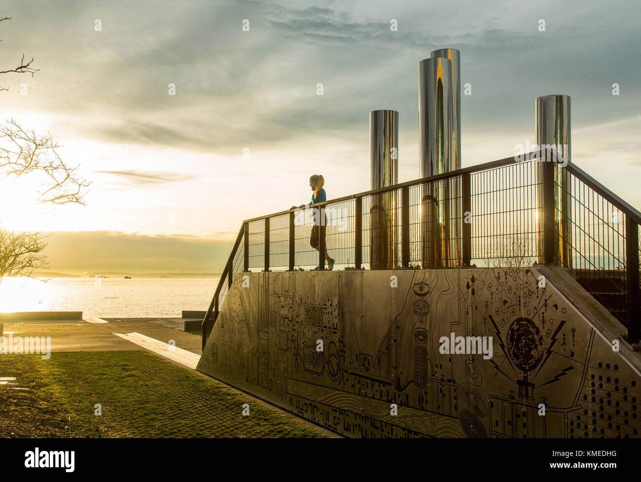 Un corridore fa una pausa e riposa su una scultura urbana nel centro di Seattle lungo il bordo del Puget Sound. Foto Stock