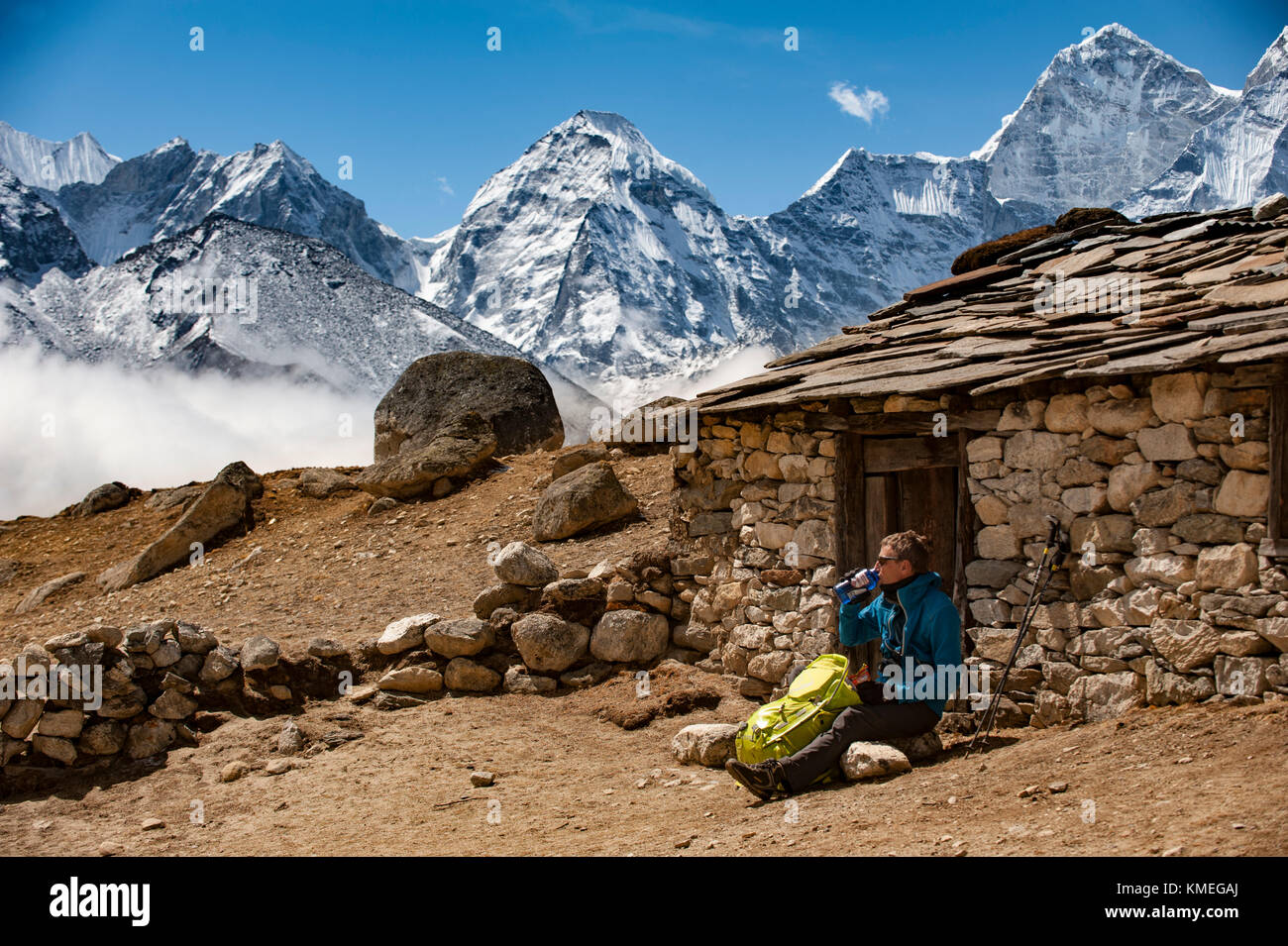 Uomo seduto mentre riposa mentre camminando in Himalaya, Dingboche, Khumbu, distretto di Solukhumbu, Nepal Foto Stock
