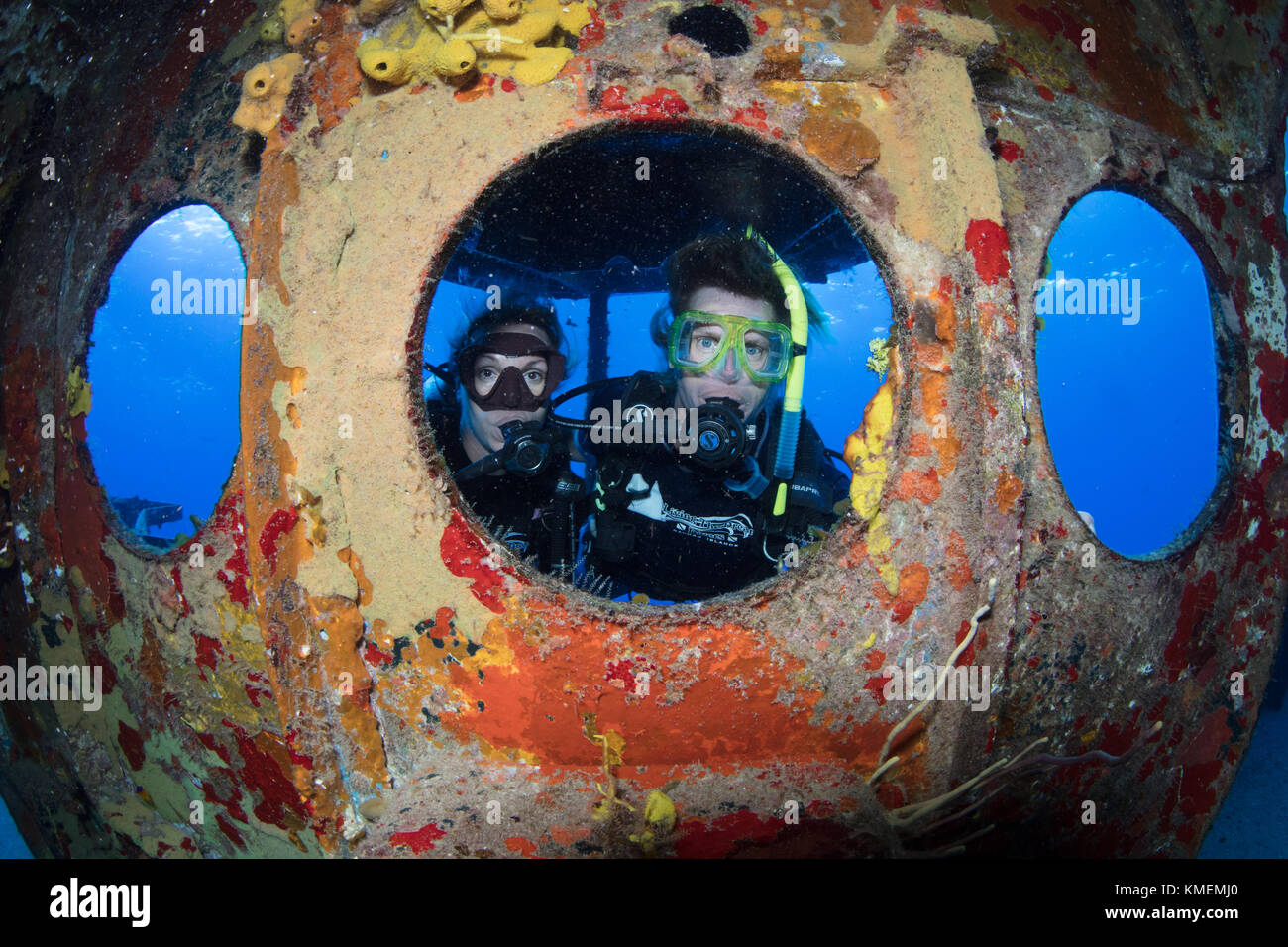 I subacquei peer attraverso oblò sulla USS kittiwake. Foto Stock