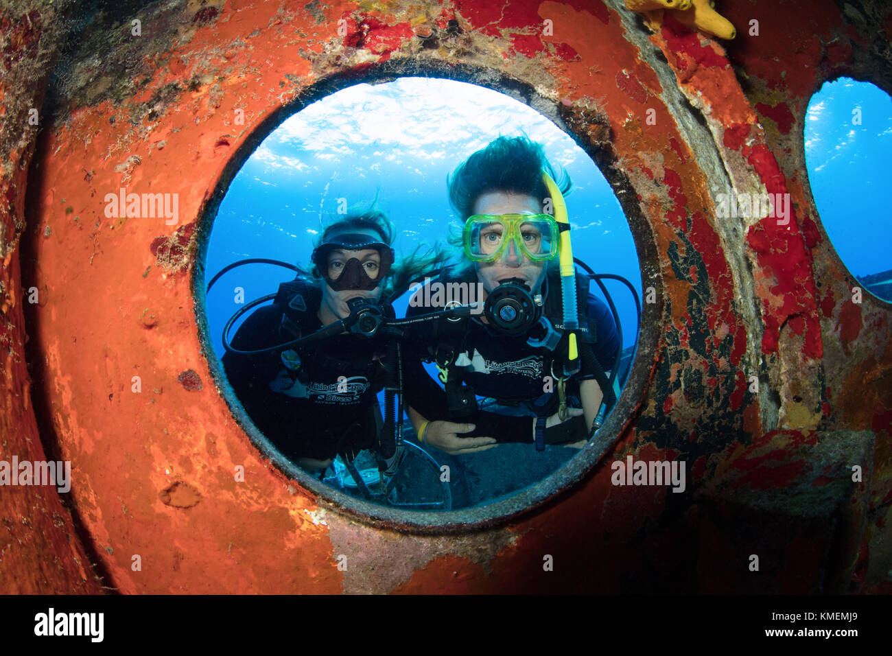 I subacquei peer attraverso oblò sulla USS kittiwake. Foto Stock