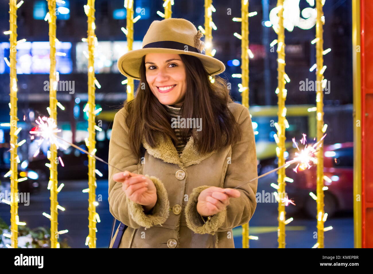 Ragazza con il fuoco brilla con festosa sfondo illuminato Foto Stock
