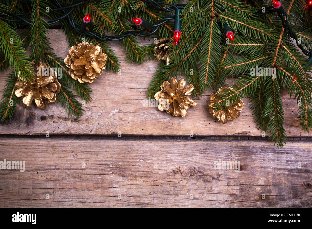 Albero di natale con coni d'oro ang luci. Sfondo di legno. Copia dello spazio. Foto Stock