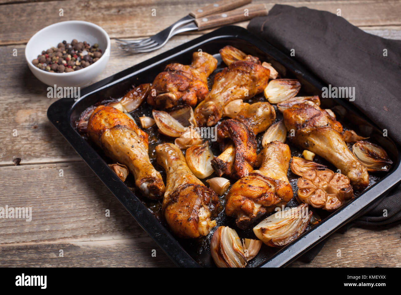 Cosce di pollo al forno con cipolle, aglio e un misto di peperoni su sfondo  di legno scuro primo piano. Vista dall'alto con spazio di copia Foto stock  - Alamy