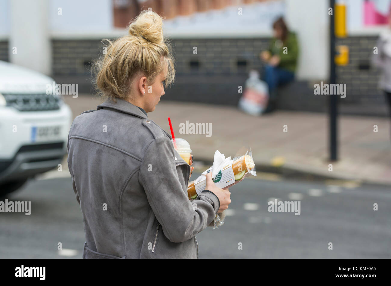 Giovane donna a piedi con spuntini leggeri per pranzo. Foto Stock