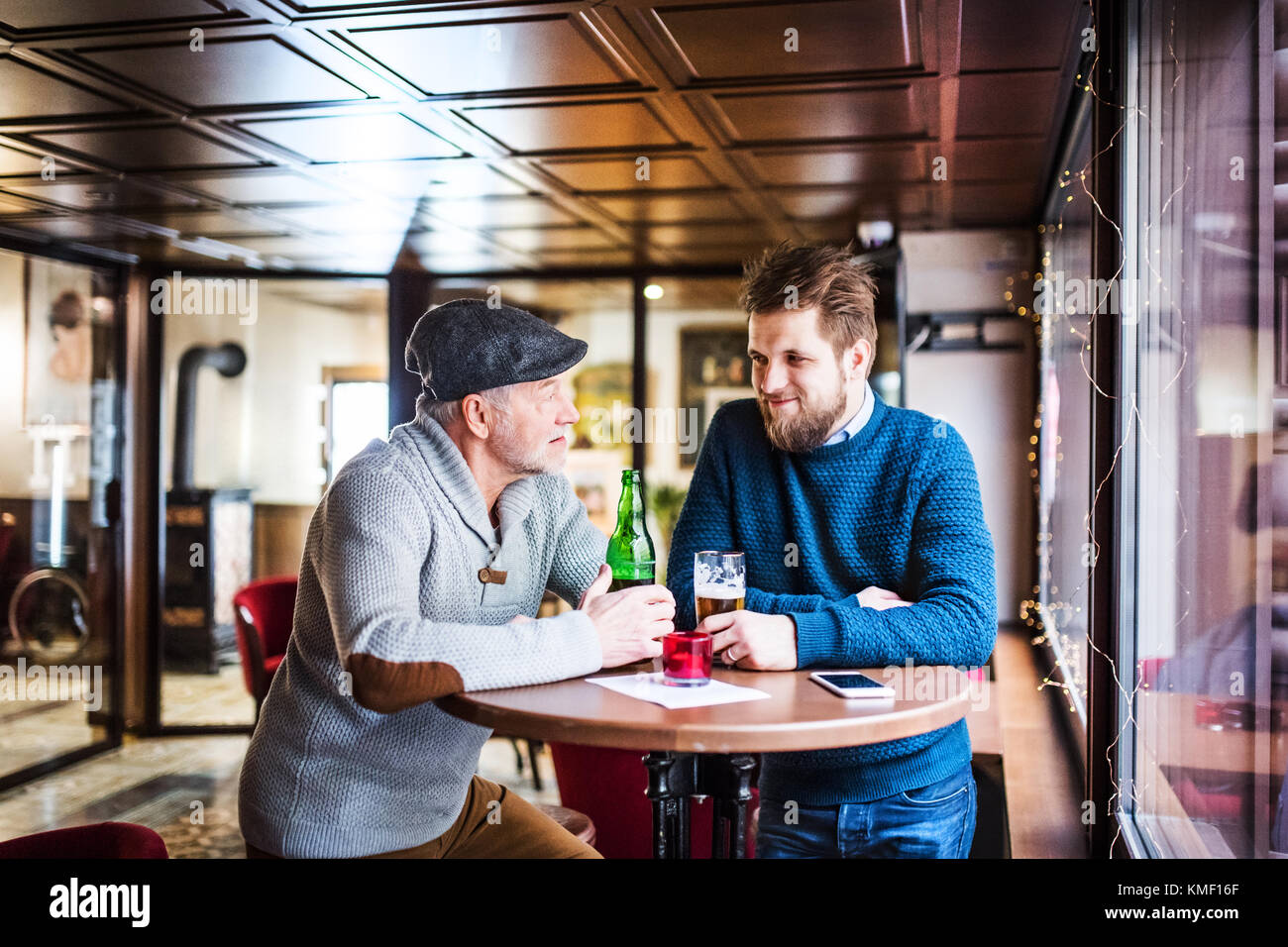 Padre senior e il suo giovane figlio in un pub. Foto Stock