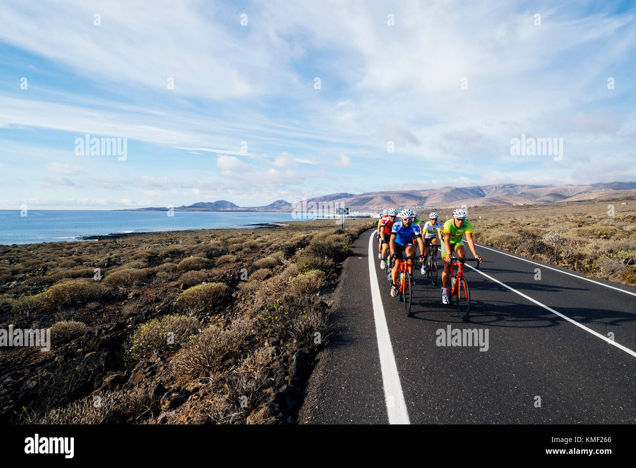 Un gruppo di ciclisti su strada equitazione sulla strada vicino alla costa, Lanzarote, Isole Canarie, Spagna Foto Stock