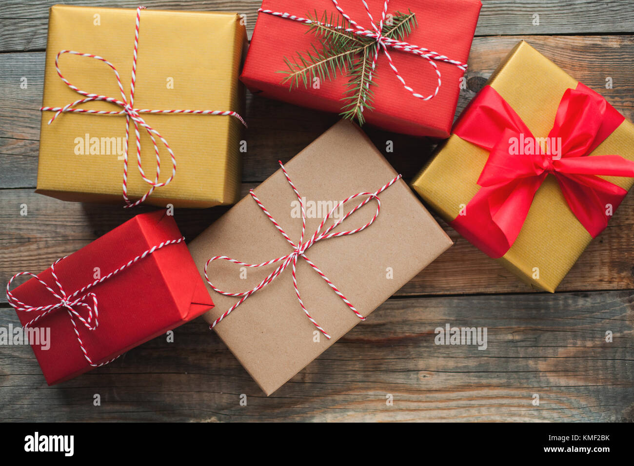 Sfondo di Natale con scatole regalo su sfondo di legno. Vista dall'alto. Regali multicolore splendidamente confezionati per il nuovo anno o il giorno del santo Foto Stock