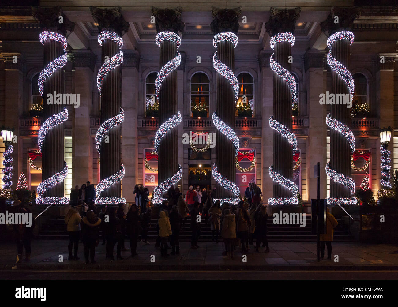 I clienti e i passanti da godere le luci di Natale intorno alle colonne corinzie del ristorante The Dome in George Street nella zona nuova di Edinburgo. Foto Stock