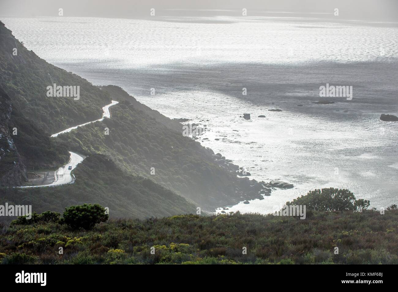 La strada di montagna sulla costa dell'oceano durante il piovoso, wet weather. Foto Stock