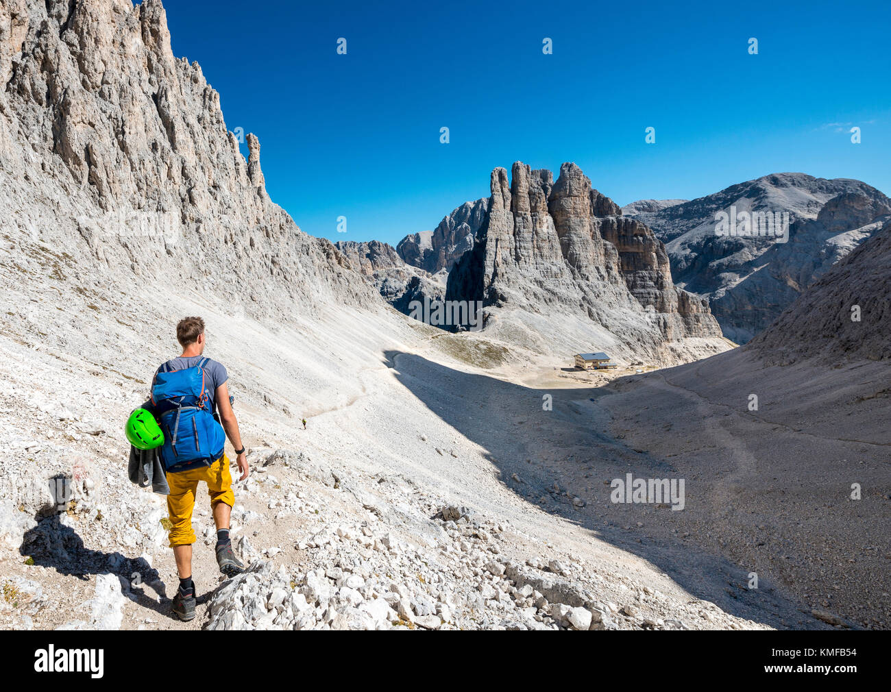 Escursionista discendente dalla Santner via ferrata al rifugio Gartl, Rifugio Re Alberto, sul retro climbing cliffs, Vajolett torri Foto Stock