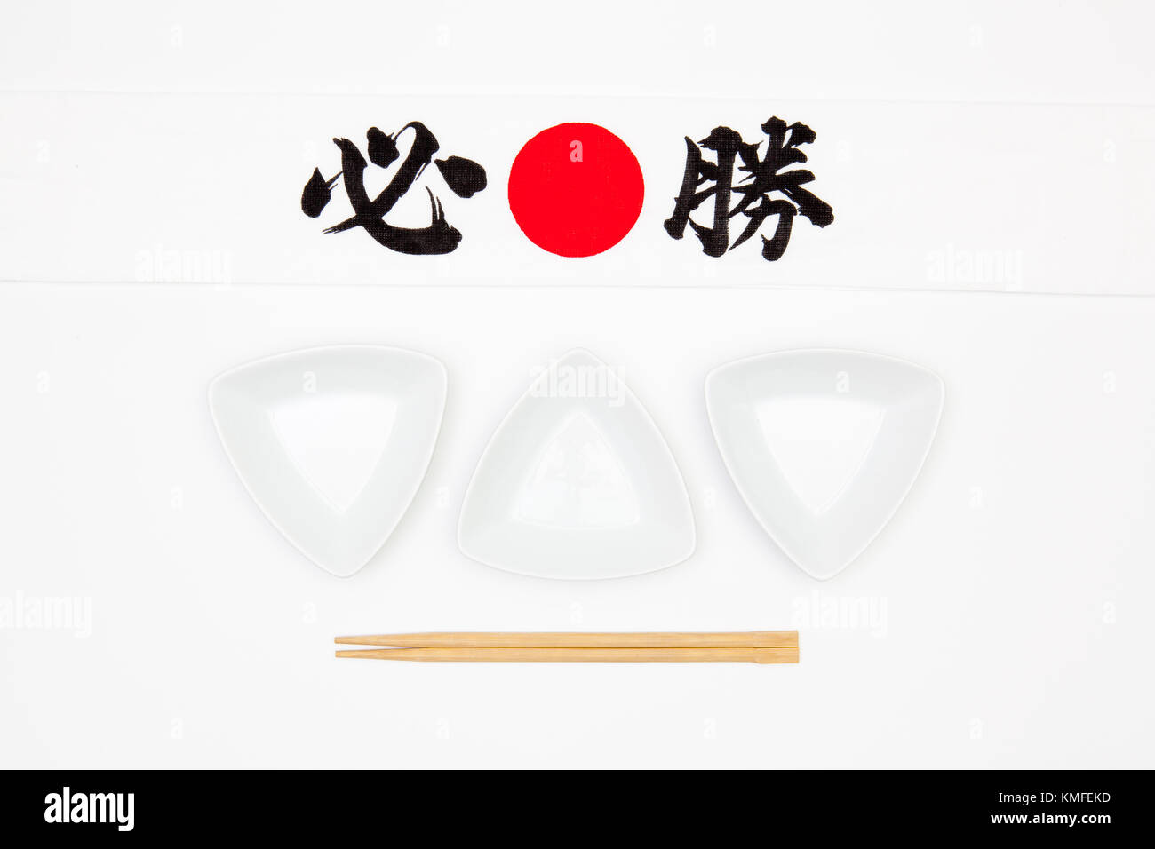 Archetto giapponese chiamato 'goukaku hachimaki' e coppe in ceramica e bambù bacchette per sushi il cibo sulla tavola bianco Foto Stock