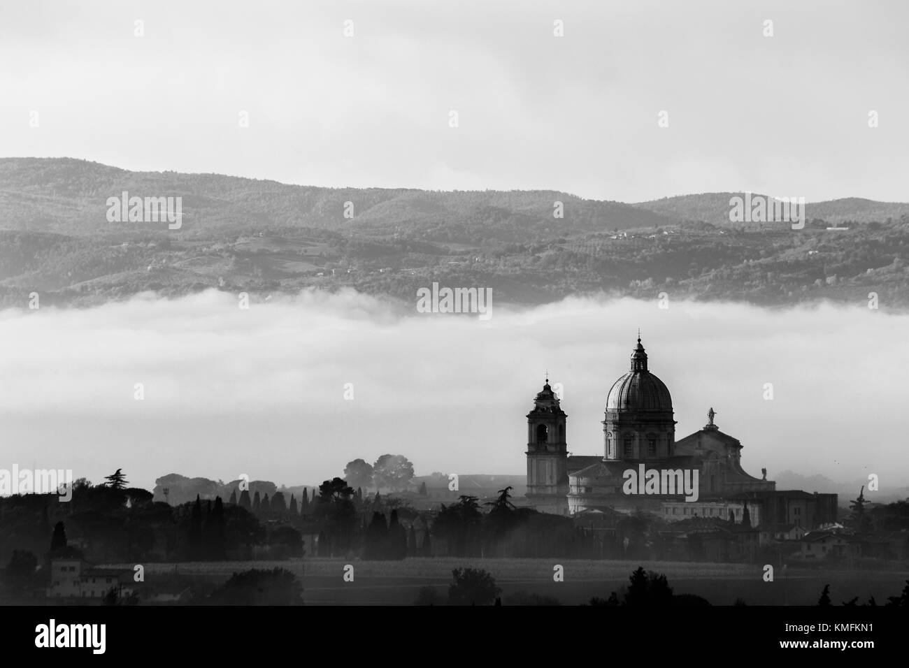 Vista della chiesa di Santa Maria degli Angeli (Assisi) contro uno sfondo di nebbia all'alba Foto Stock