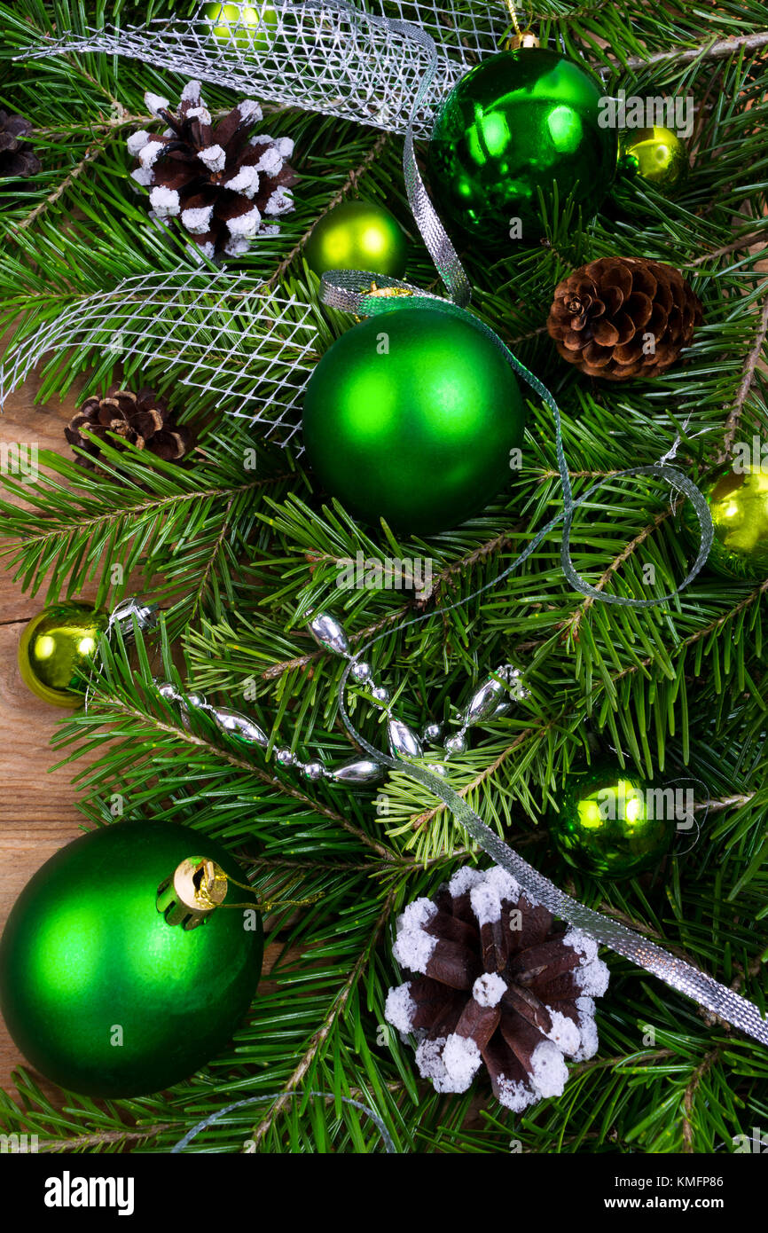 Natale con sfondo verde baubles, pigne, nastro argentato e perline swag Foto Stock