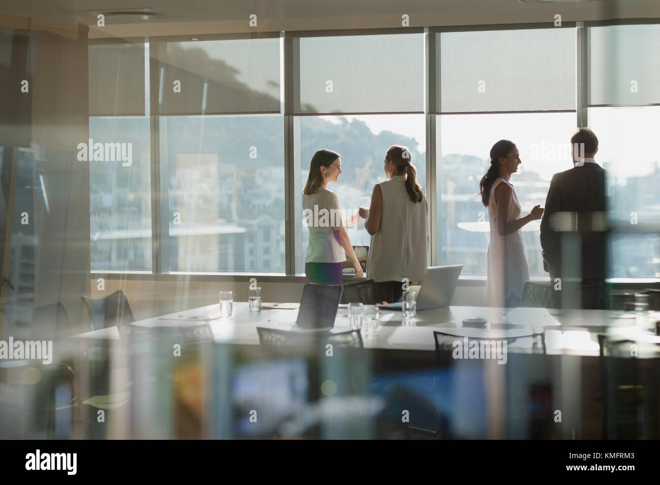 La gente di affari parlando a finestra piena di sole in sala conferenza incontro Foto Stock