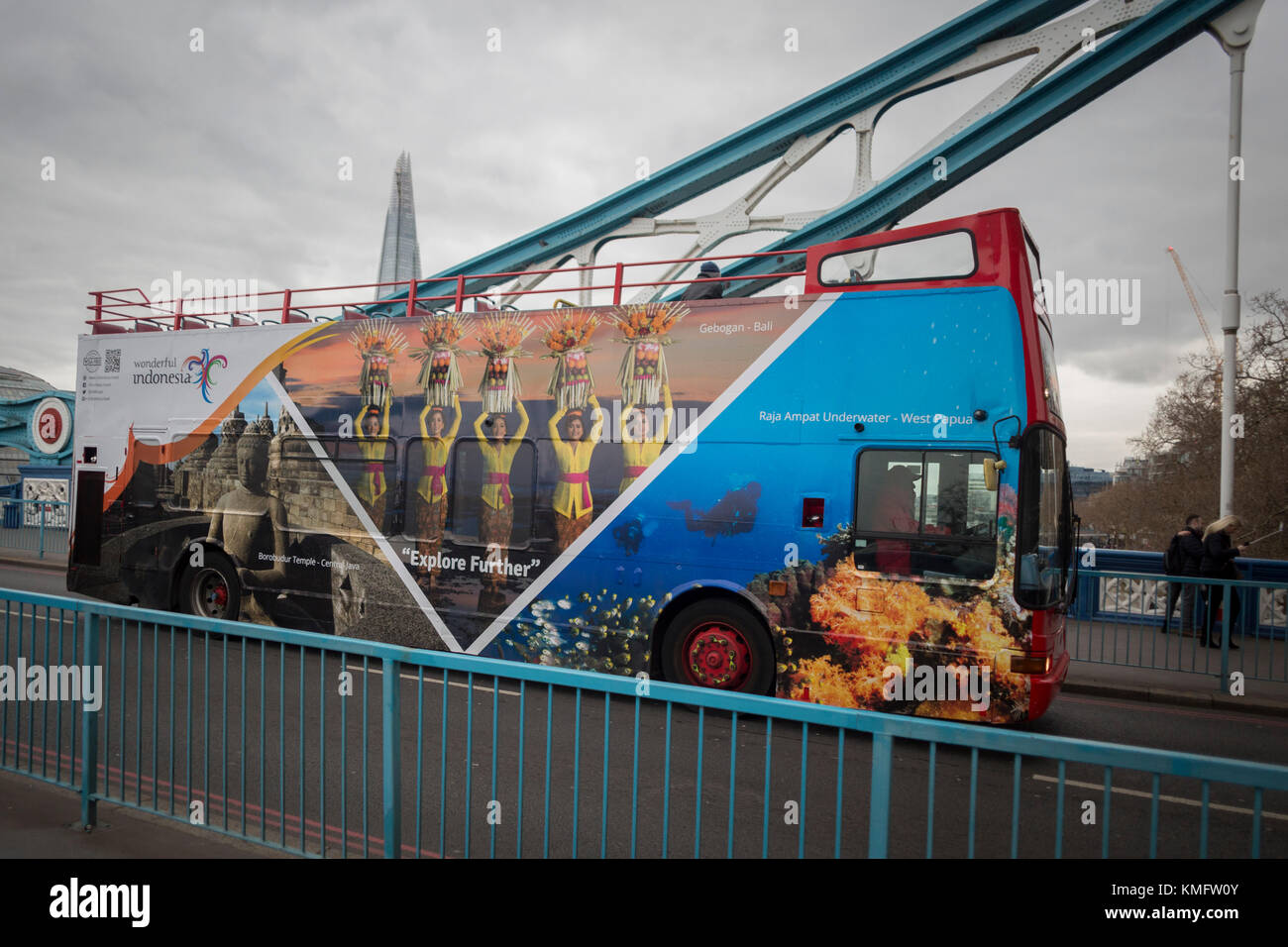 Un London tour bus dotato di un marketing campagna pubblicitaria per il turista indonesiano board attraversa il Tower Bridge, il 6 dicembre 2017, a Londra Inghilterra. Foto Stock