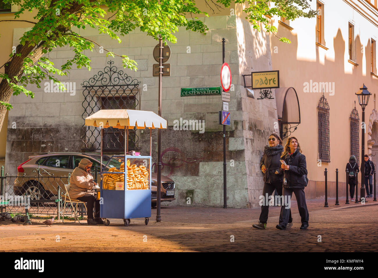 Città vecchia di Cracovia, vista di due donne maturo turisti passeggiando davanti a un pretzel stand in una piazza nel quartiere della città vecchia (stare Miasto) di Cracovia, Polonia Foto Stock