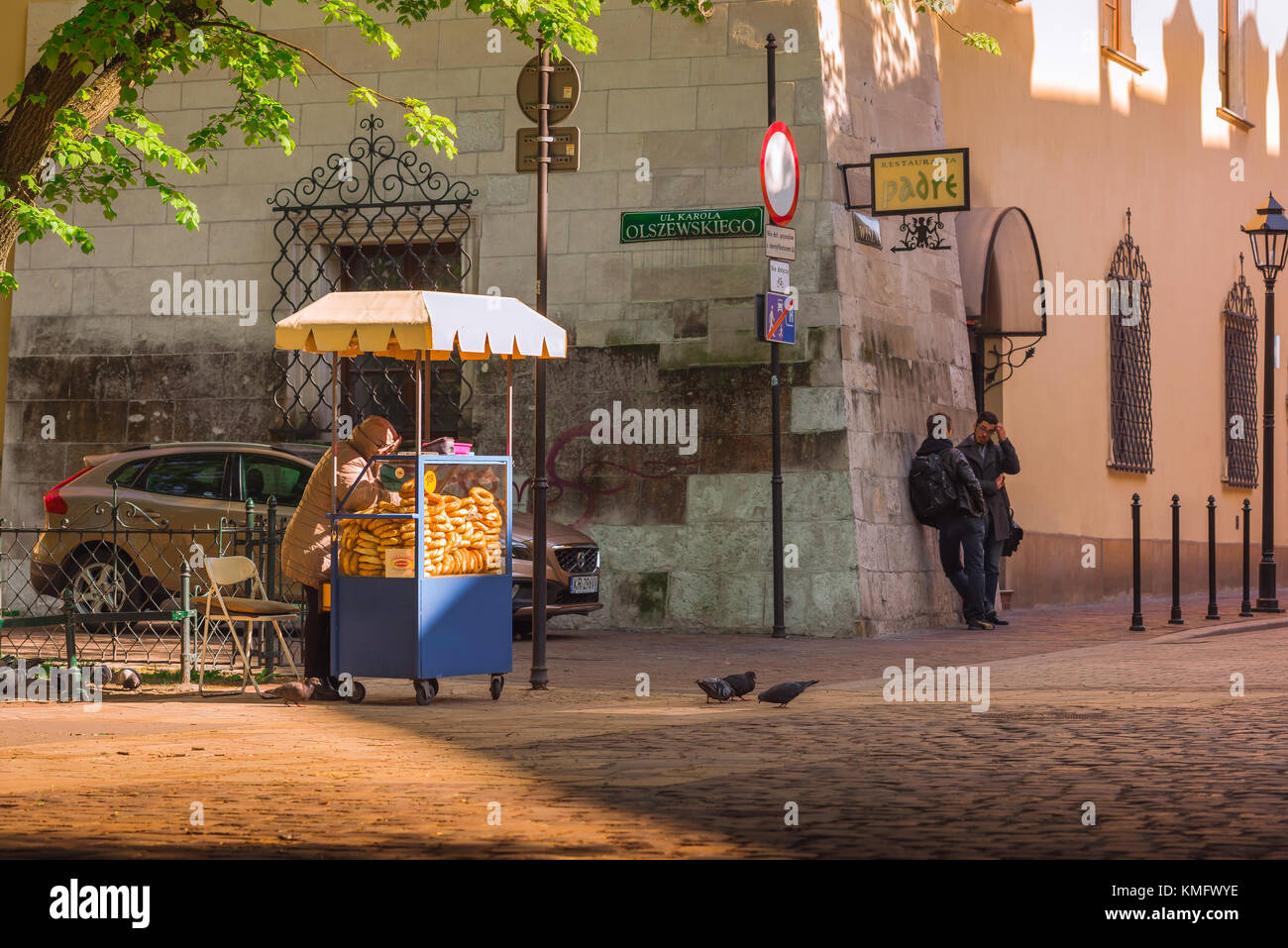Cibo di strada in Polonia, vista di un venditore che prepara il suo stand pretzel in una piazza nella zona centrale della città vecchia di Cracovia, Polonia. Foto Stock