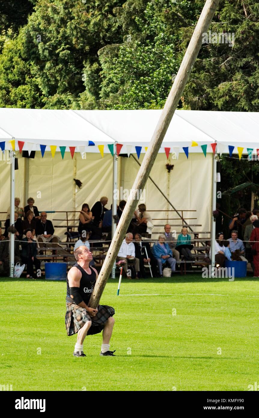 Lonach Highland Games a Strathdon, Grampian, Scotland, Regno Unito. Concorrente indossando il tradizionale kilt lanciare la caber Foto Stock