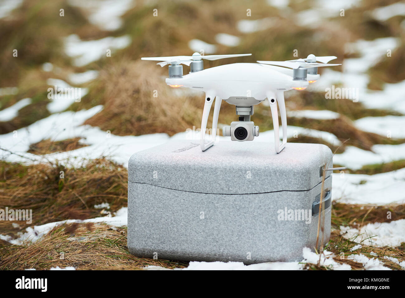Minsk, Bielorussia - 3 dicembre 2017: dji phantom 4 pro drone soggiorno su grigio trasportare casella sul cresciuta con la neve Foto Stock