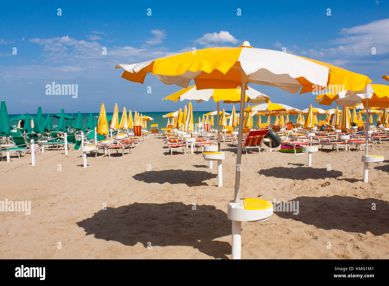 La Costa sul mare adriatico. vista mare d'Italia, estate ombrelloni sulla spiaggia sabbiosa con nubi all orizzonte Foto Stock