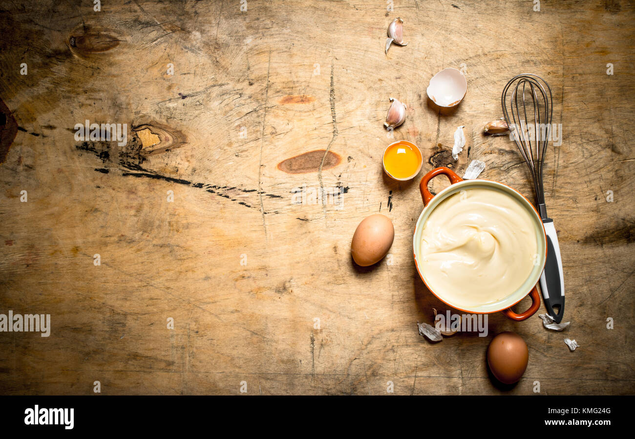 La maionese nella ciotola con gli ingredienti per cucinare. su sfondo di  legno Foto stock - Alamy