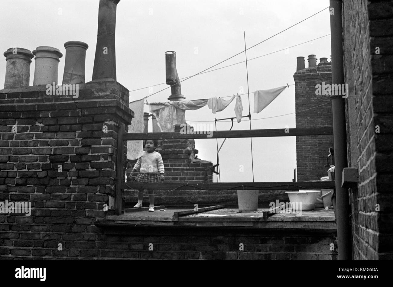 Slum povertà Londra anni '60 Regno Unito. Etnico, britannico nero bambino che gioca sulla terrazza del tetto della terrazza vittoriana delle baraccopoli 1967 UK HOMER SYKES Foto Stock