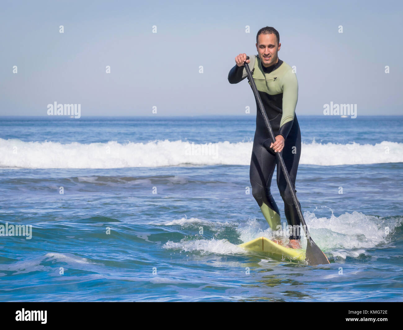 Uomo che naviga con un stand up paddling Board a sopelana spiaggia Foto Stock
