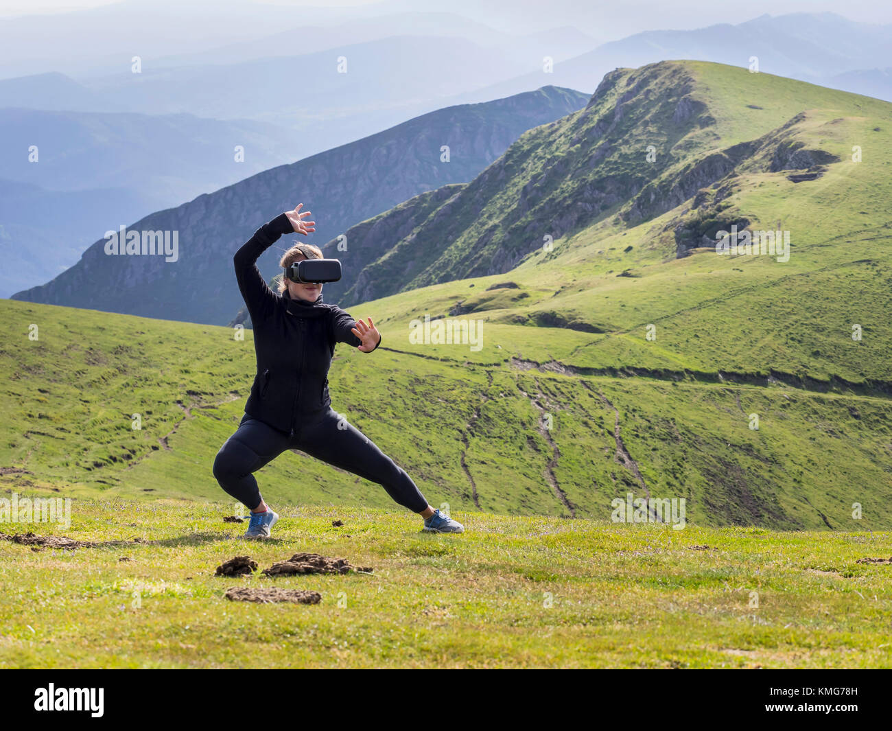 Donna che pratica il karate si muove con i vetri di realtà virtuale sulla montagna Foto Stock