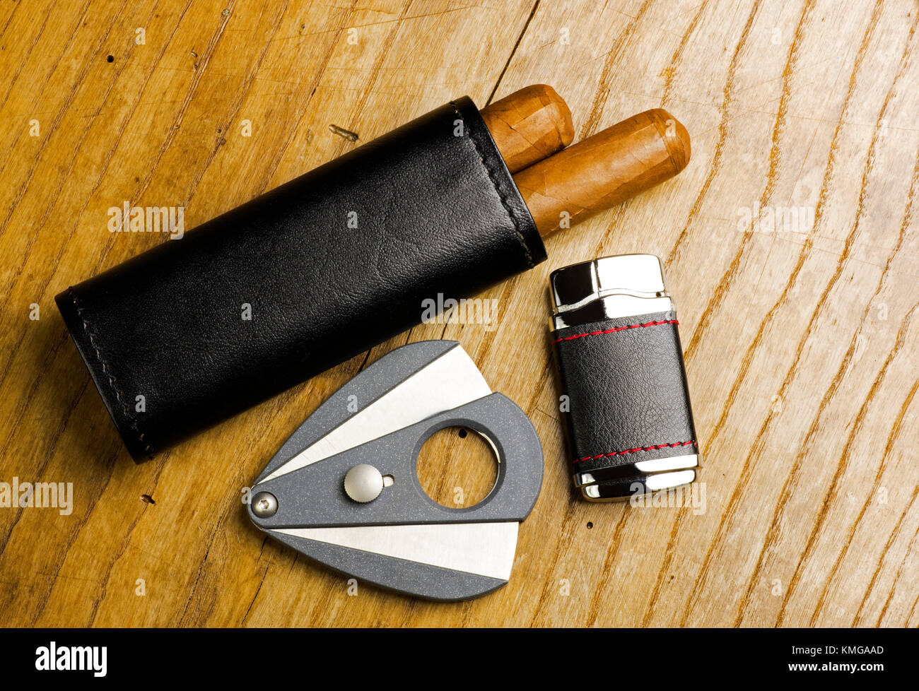 Custodia di pelle con i sigari, più leggero e il coltello da caccia su una vecchia tavola di legno Foto Stock